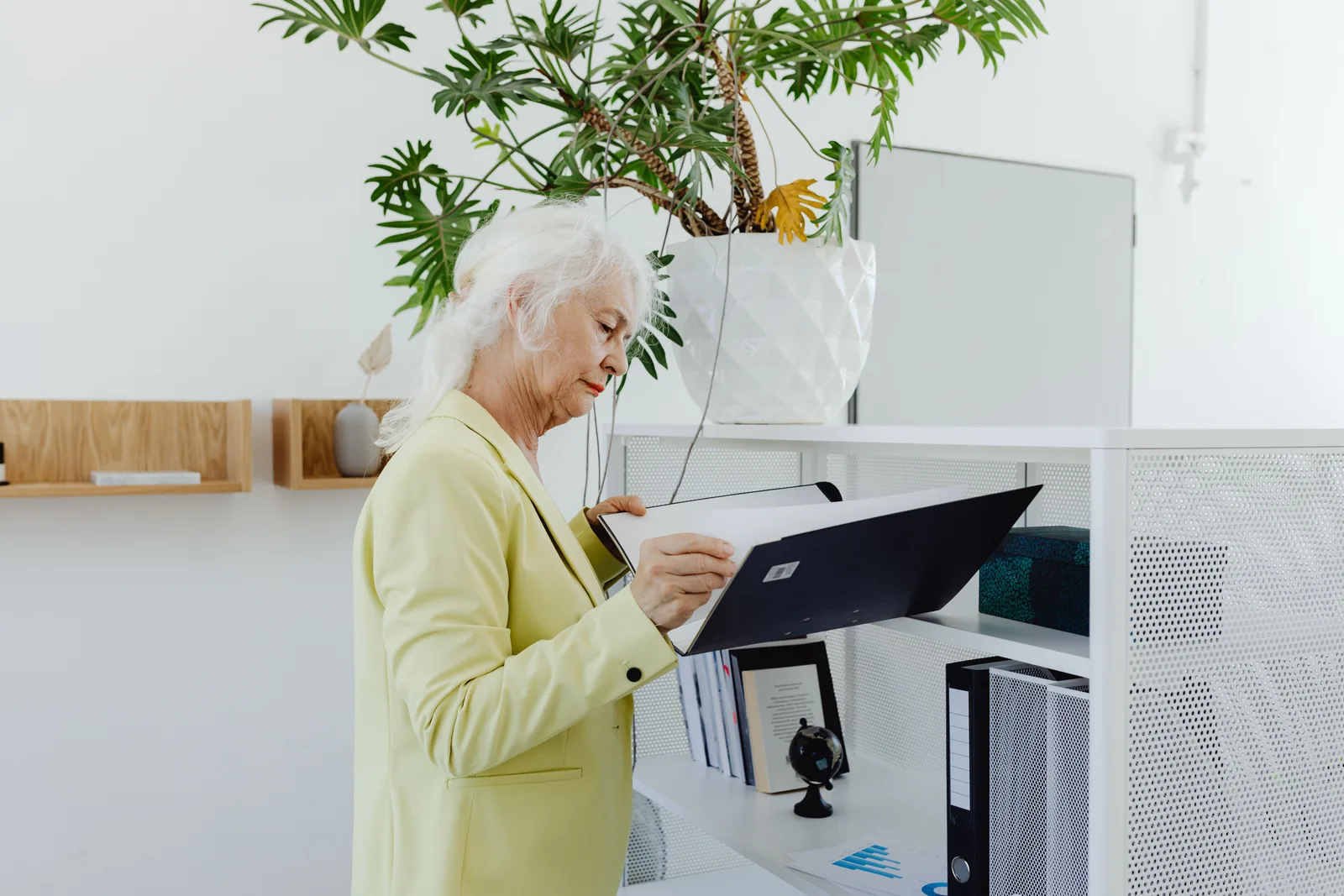 Bookkeeper in an office opening a client folder at a standing desk