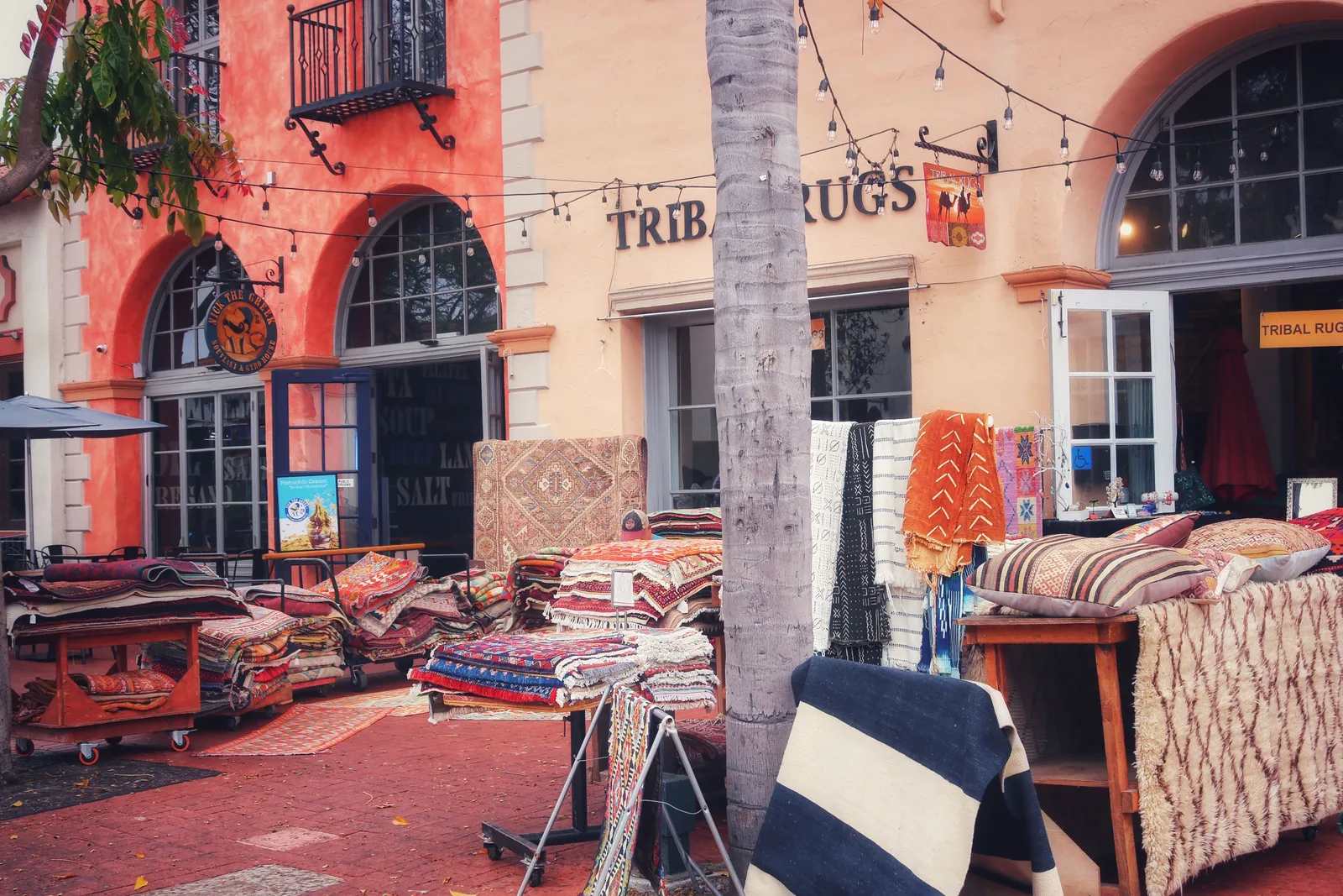Patterned rugs hanging on display outside an independent shop on a street in Santa Barbara, California