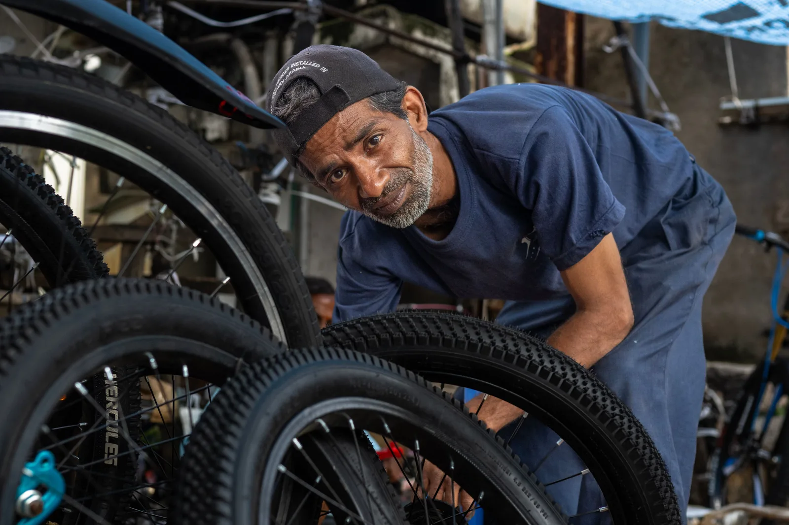 A bicycle mechanic inspecting a wheel in a workshop