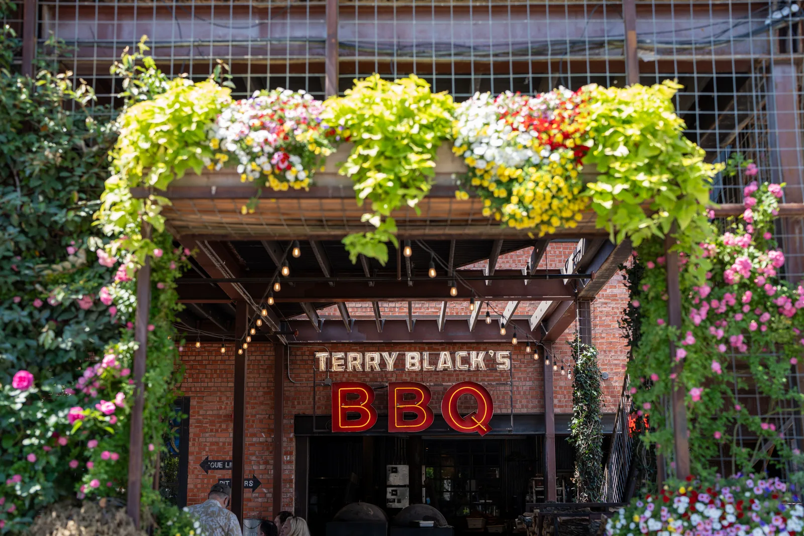The entrance of a barbecue restaurant in Dallas, Texas, with a neon sign above the door
