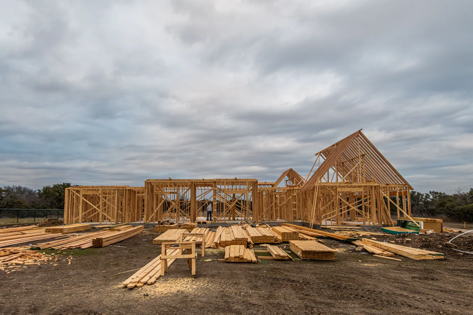 A worker framing a new home wall section on a Fort Worth construction site