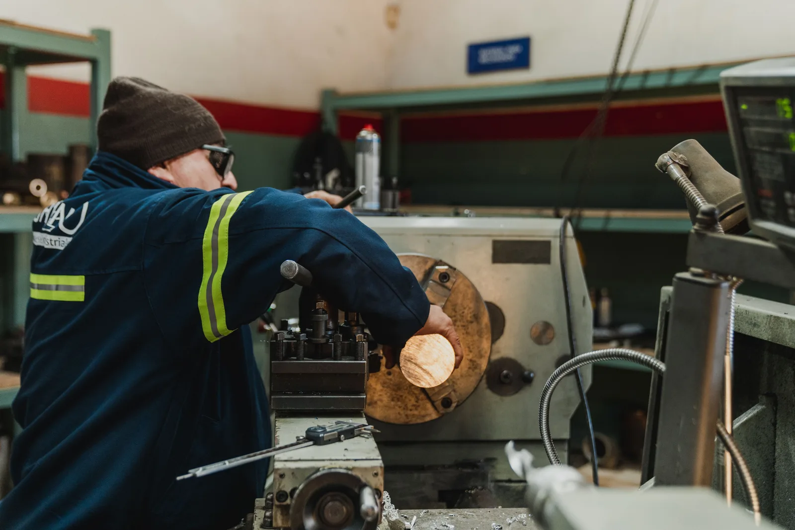 A machinist operating a lathe in a machine shop