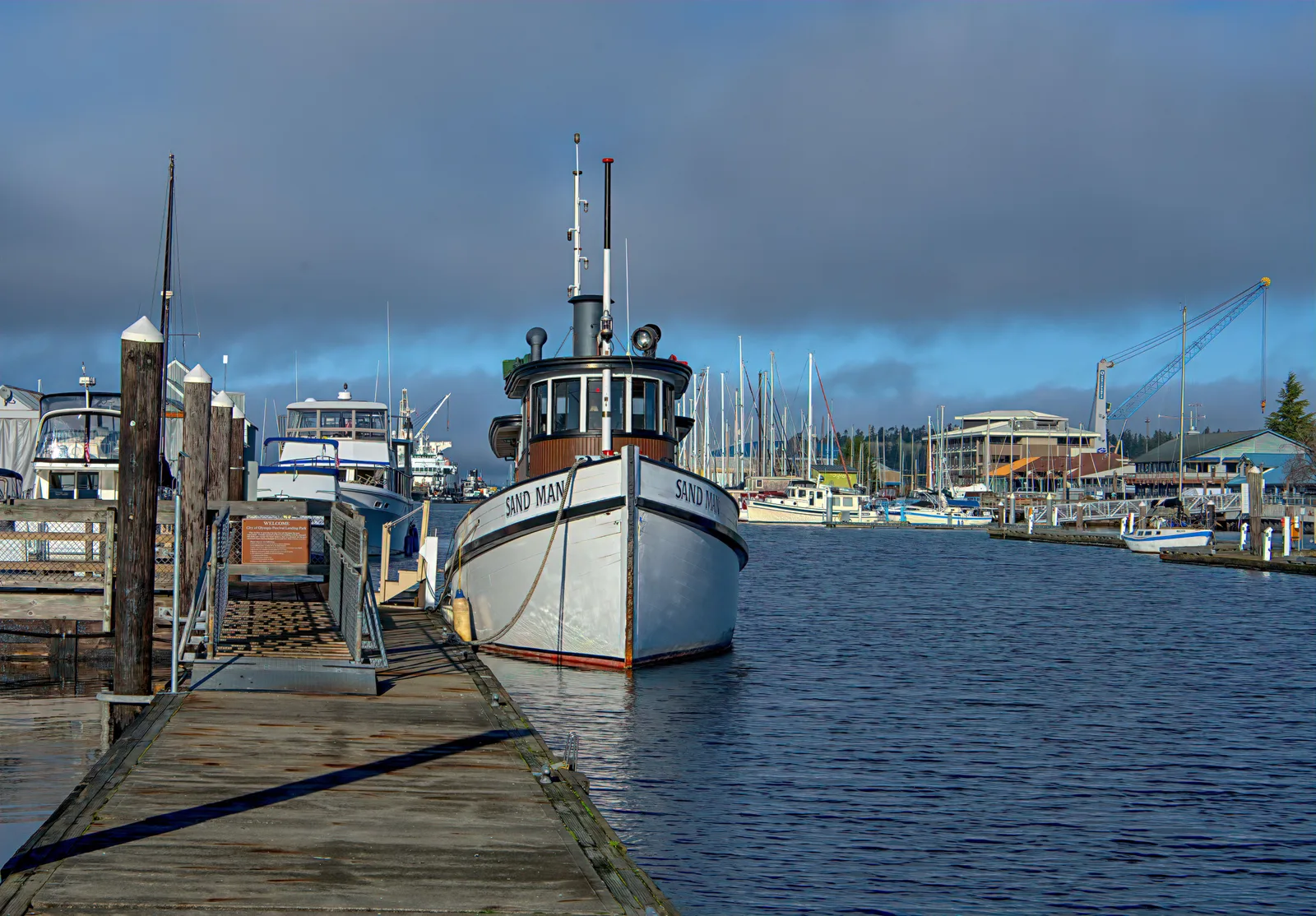 Commercial fishing boat moored at a wooden dock in a working harbor.