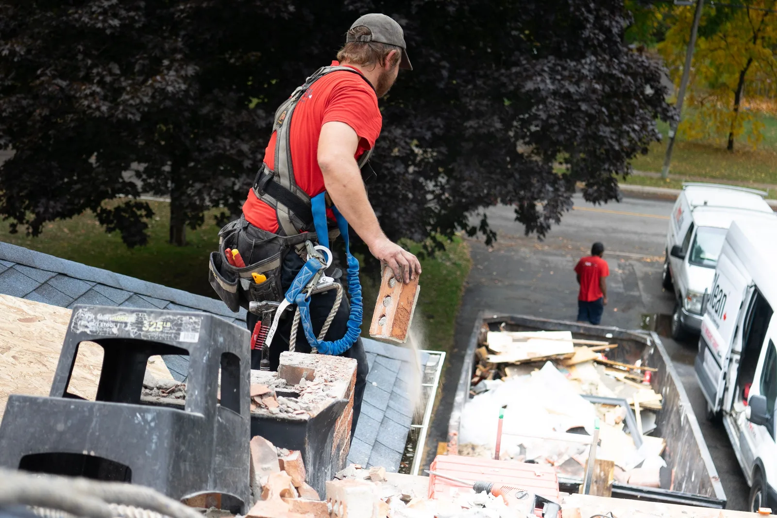Roofing tear off debris loaded into a jobsite dumpster