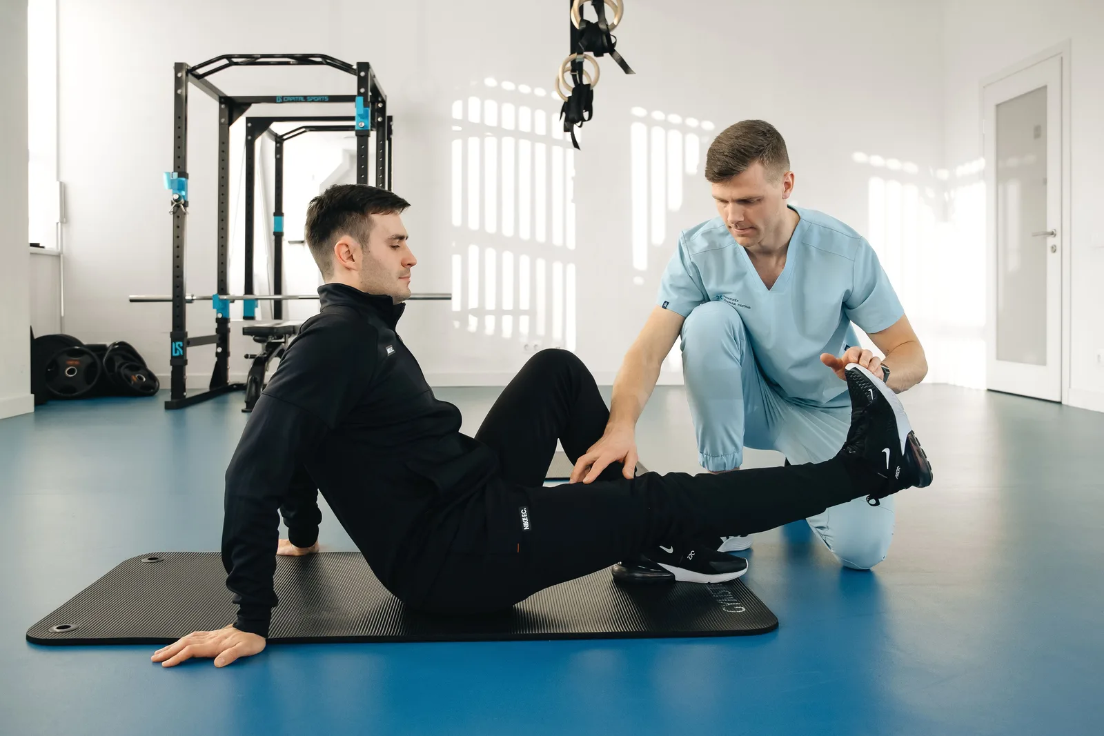 A physical therapist assisting a patient through a rehabilitation exercise during a treatment session
