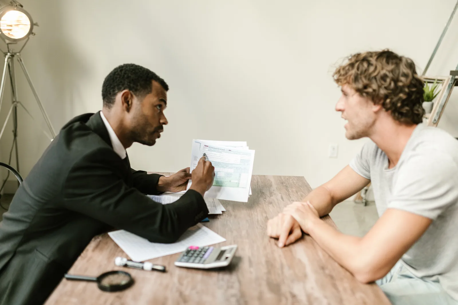 An adviser going through a tax form with a client across a desk
