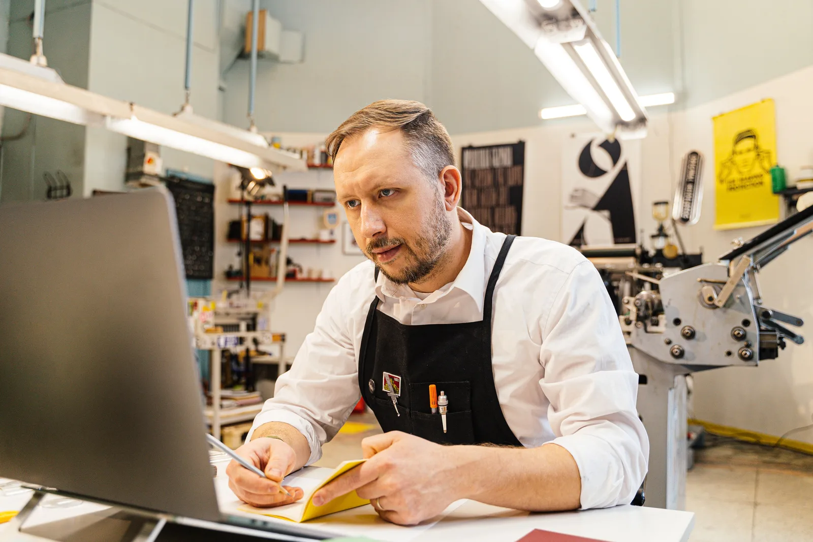 A shop owner working through paperwork at a workbench