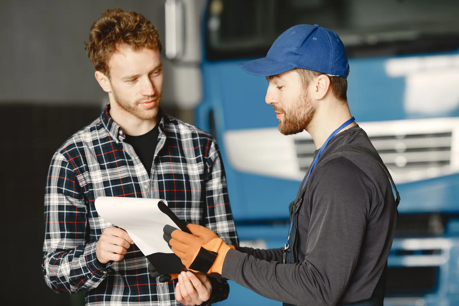 A mechanic reviewing paperwork inside a garage