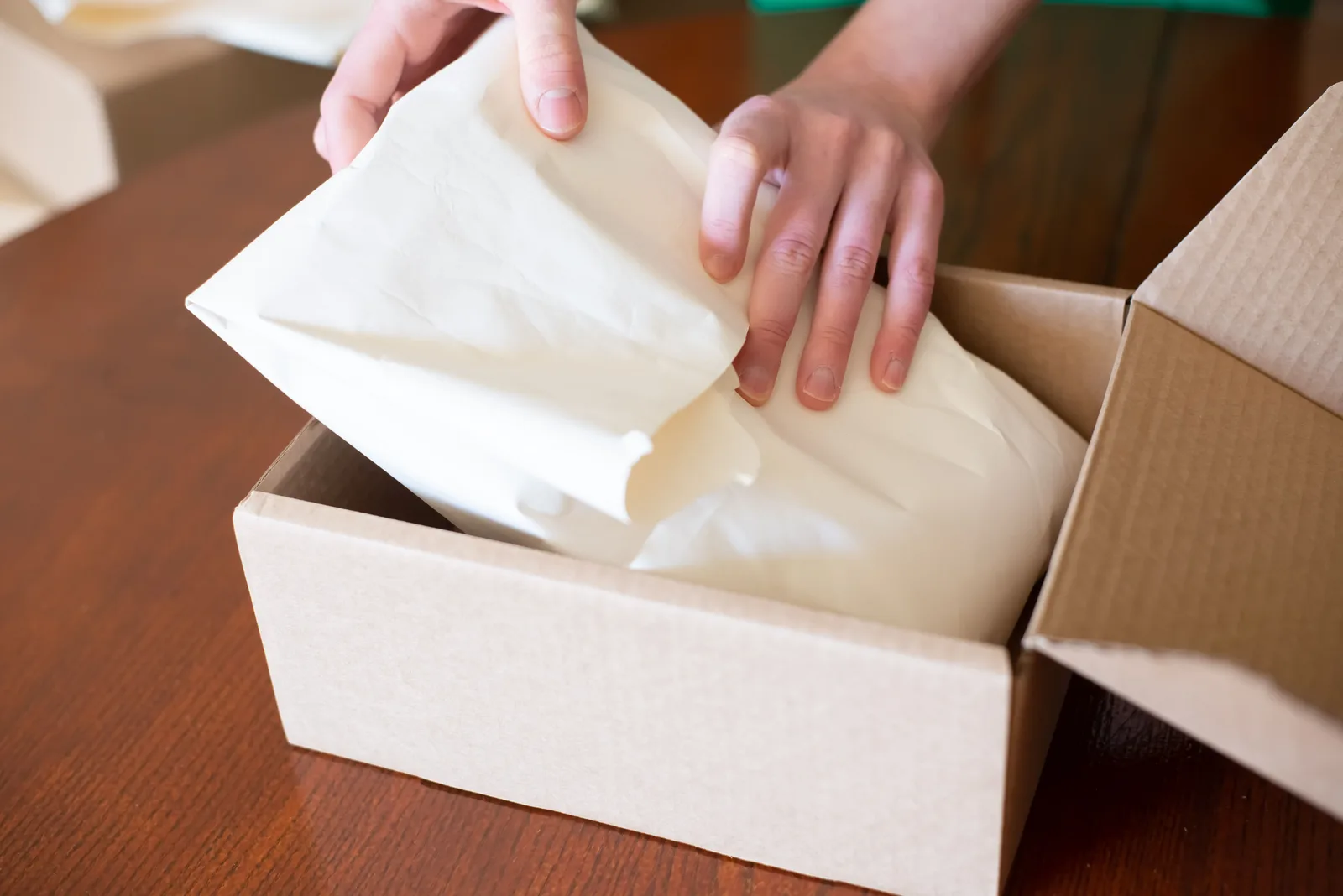 Ecommerce seller wrapping merchandise for shipment