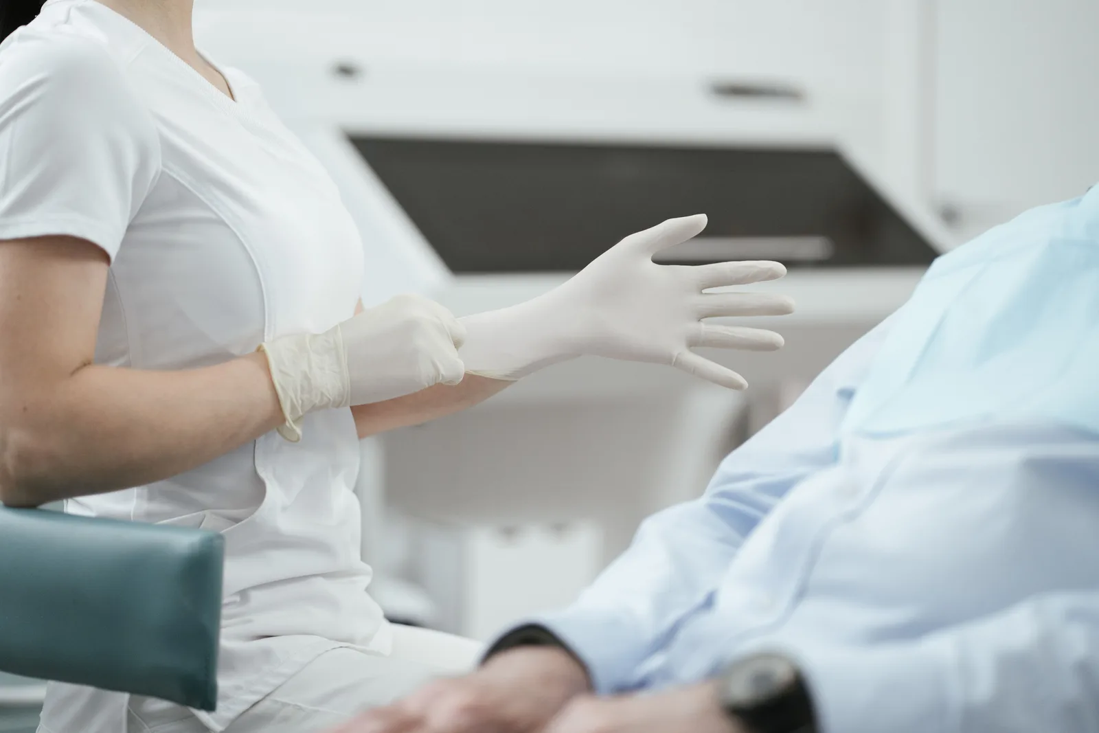 A healthcare worker pulling on a sterile glove before examining a patient