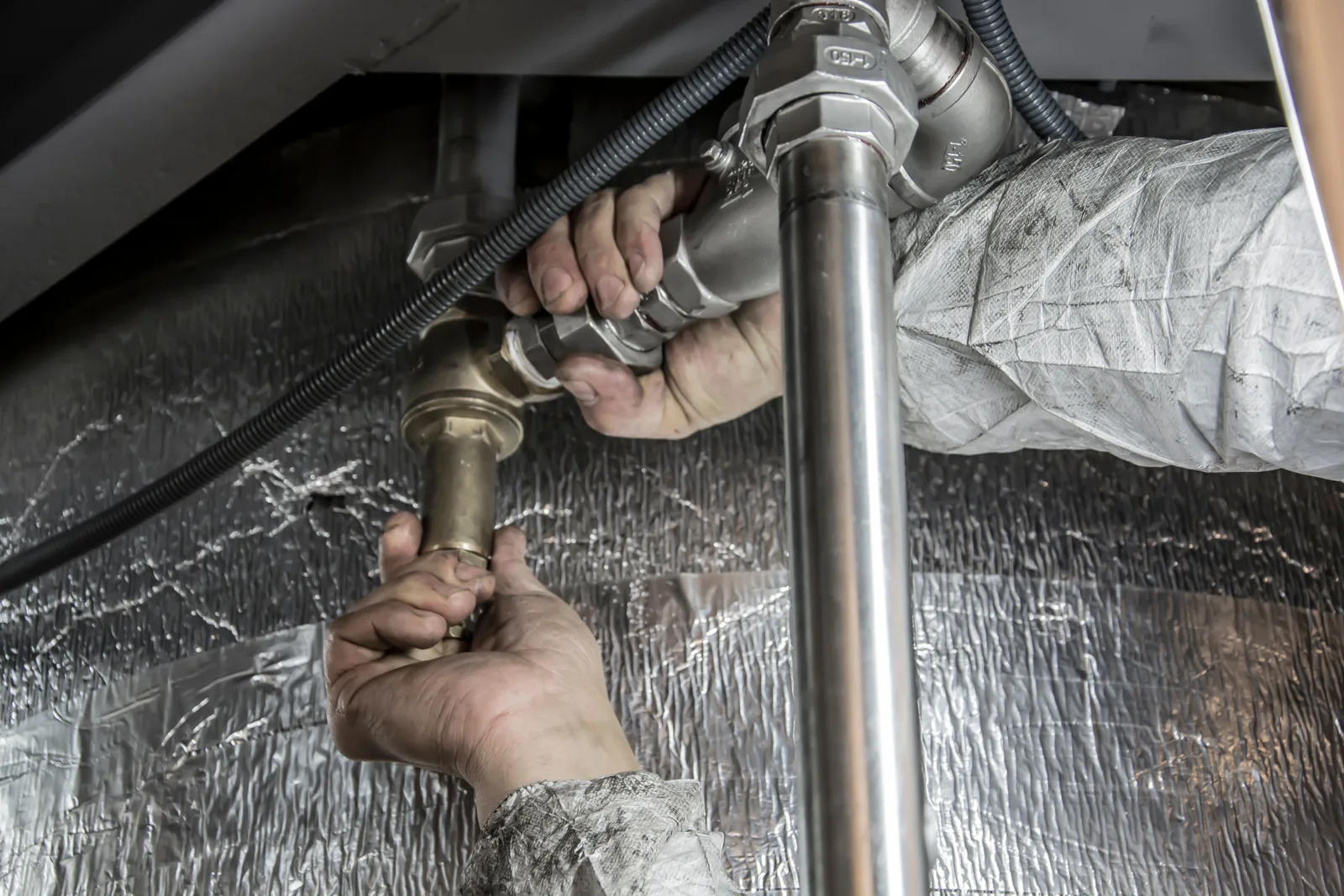 HVAC technician fitting pipework on a commercial installation