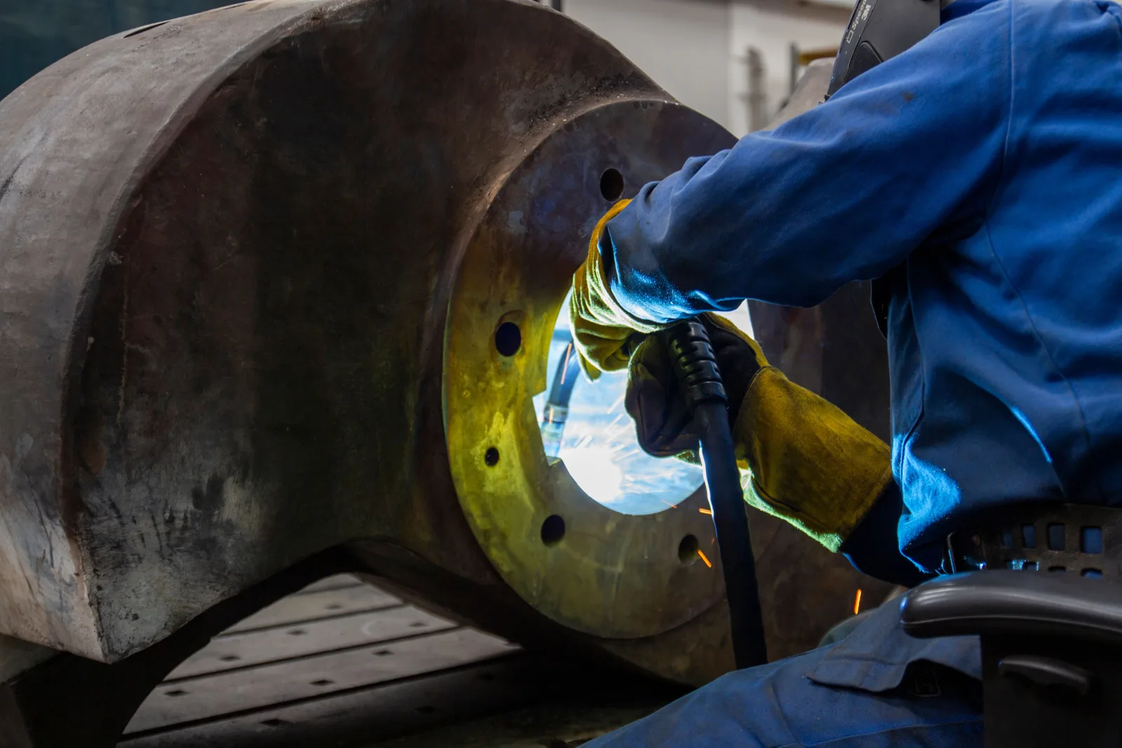 A worker welding in a metal fabrication shop