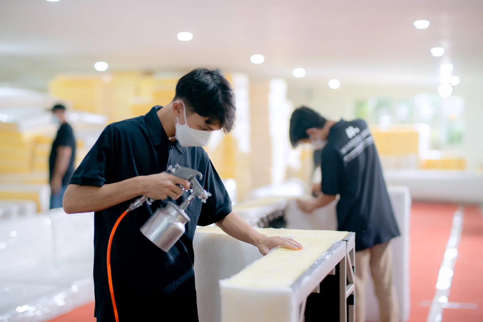 A worker finishing furniture in a workshop