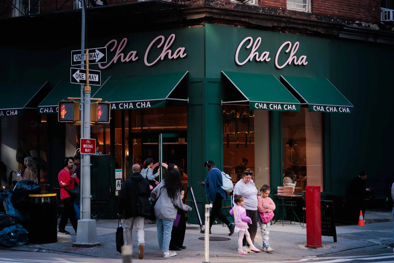 People walking past a corner restaurant on a New York City street