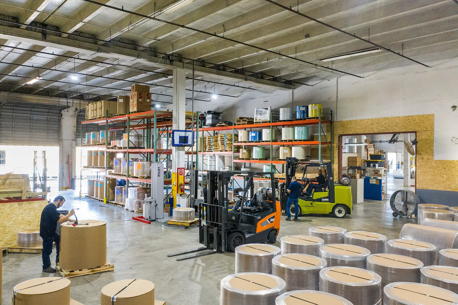 Forklifts and workers handling stock on a warehouse floor