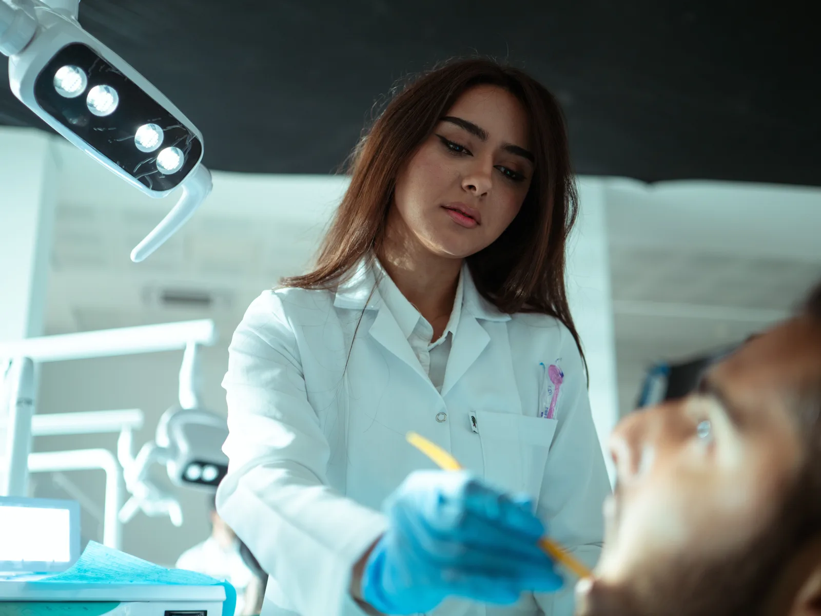 A dentist examining a patient's teeth in a dental treatment room