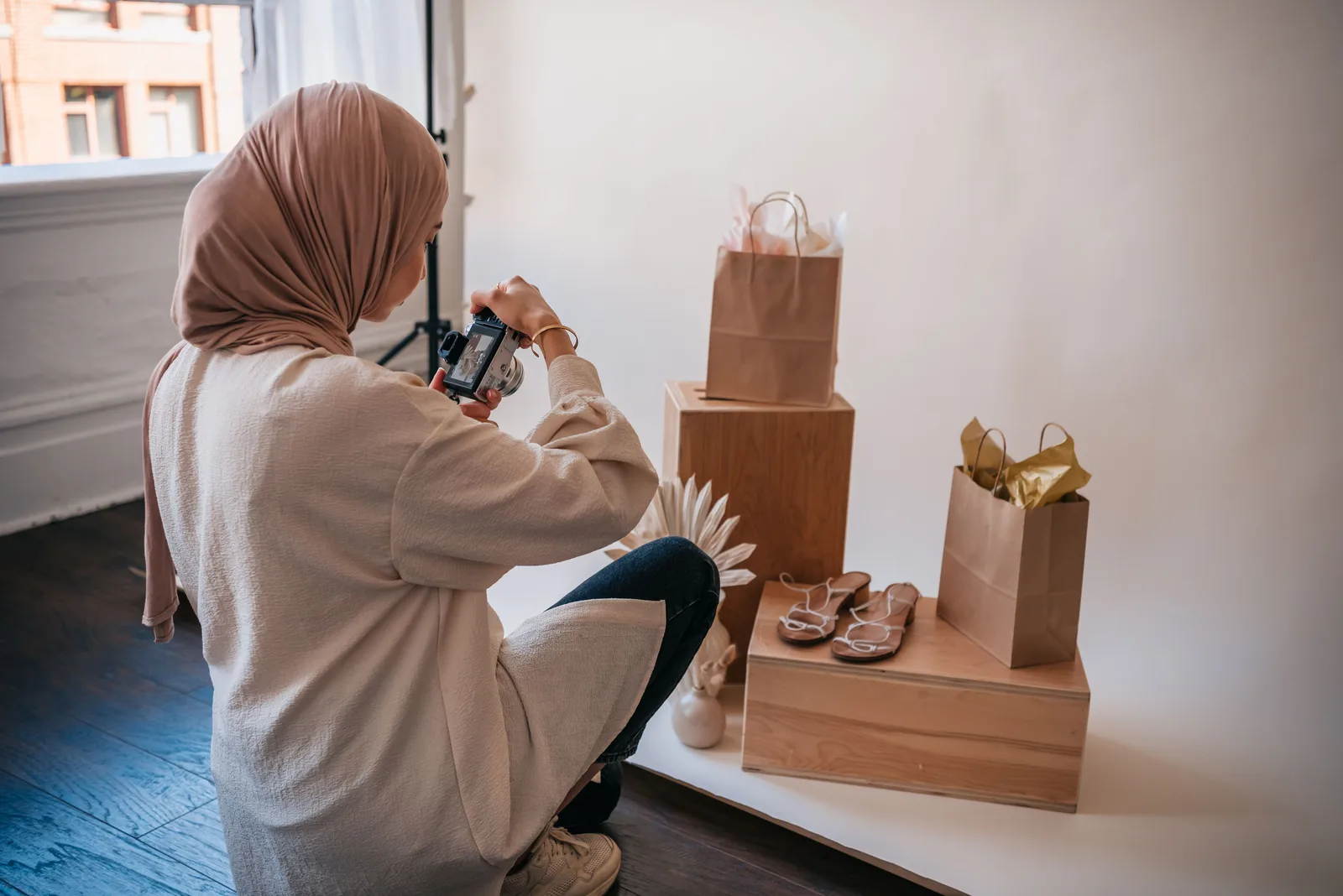Seller photographing product packaging on a lit studio floor