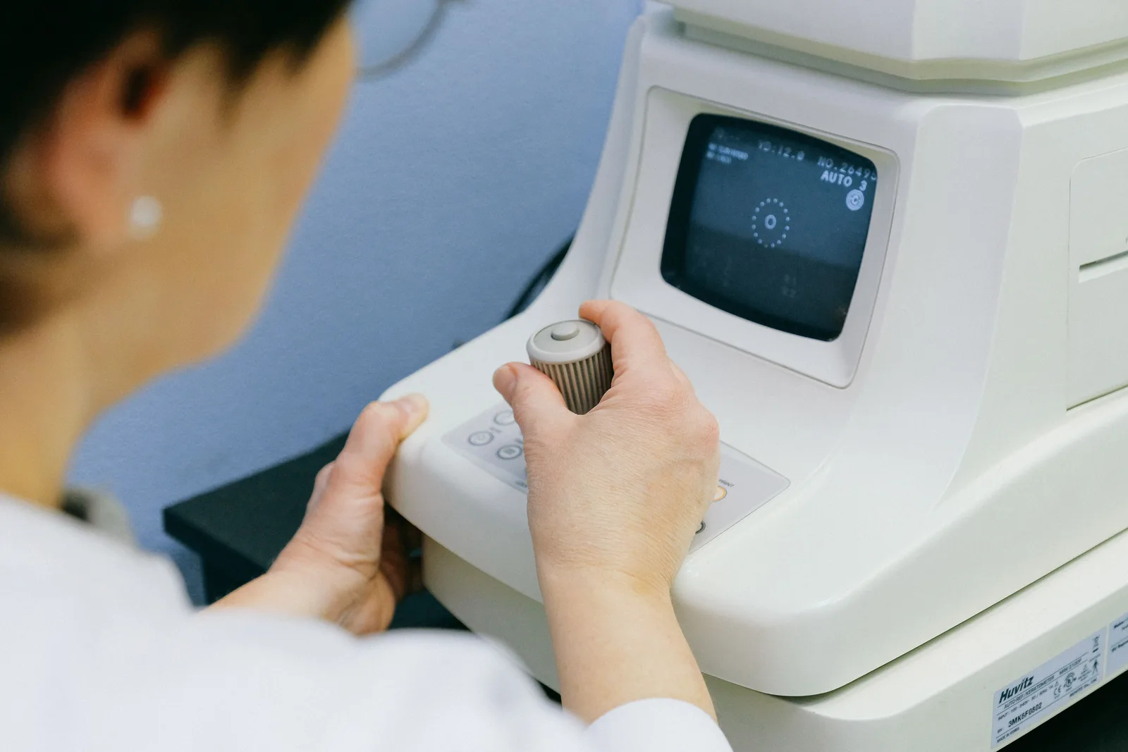 An optometrist operating an eye examination instrument in an eye clinic