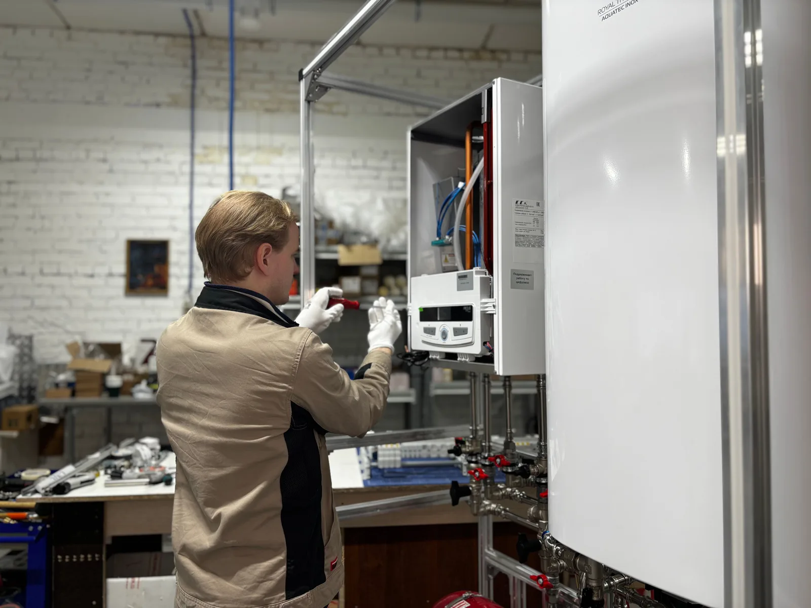 A technician inspecting and servicing a heating system inside a mechanical workshop