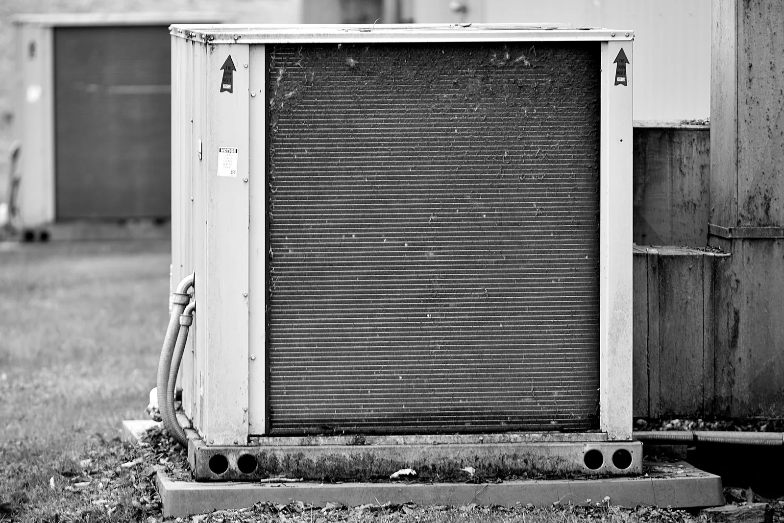 Close up of an industrial HVAC unit installed outdoors, showing its metal casing and fan grille
