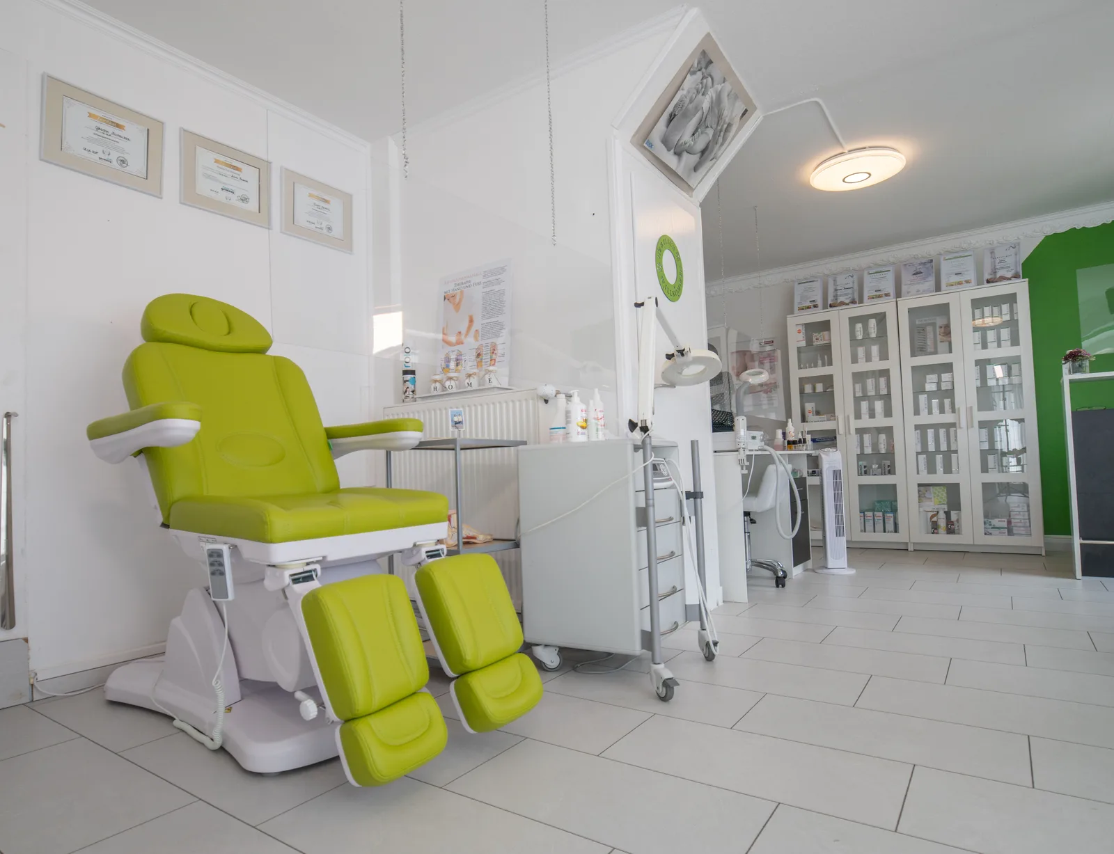 A clinic treatment room with a procedure chair and equipment cabinets