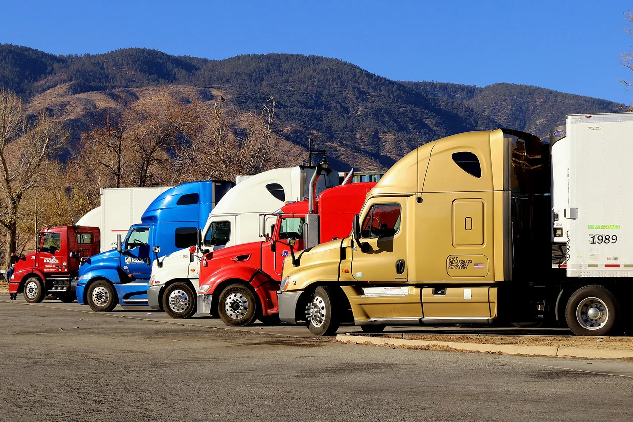 Row of semi tractors parked in a trucking company lot
